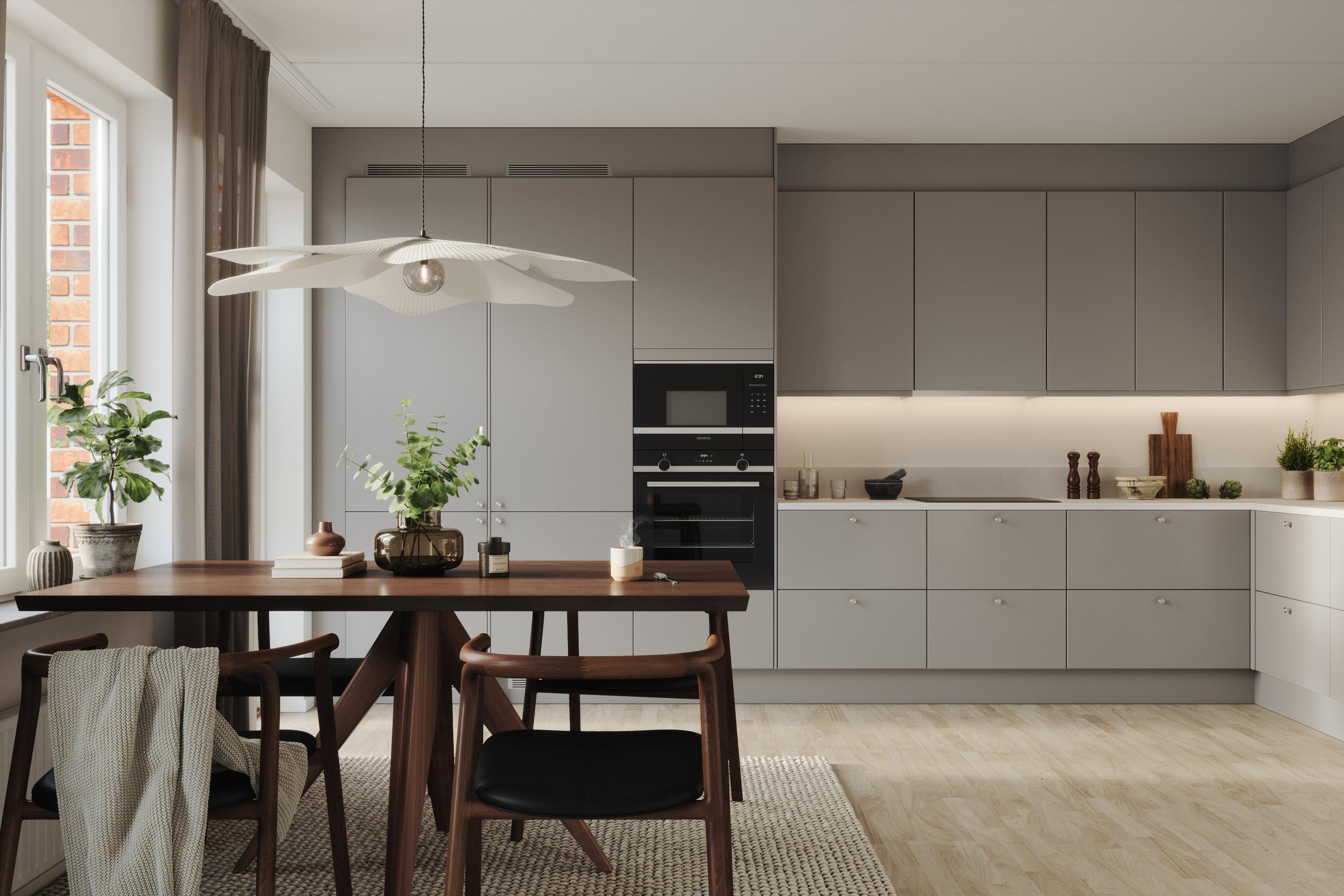 Köket är välplanerat med tidlösa materialval såsom stenkompositskiva och släta luckor. Vitvarorna är helintegrerade för ett stilrent uttryck (visionsbild).