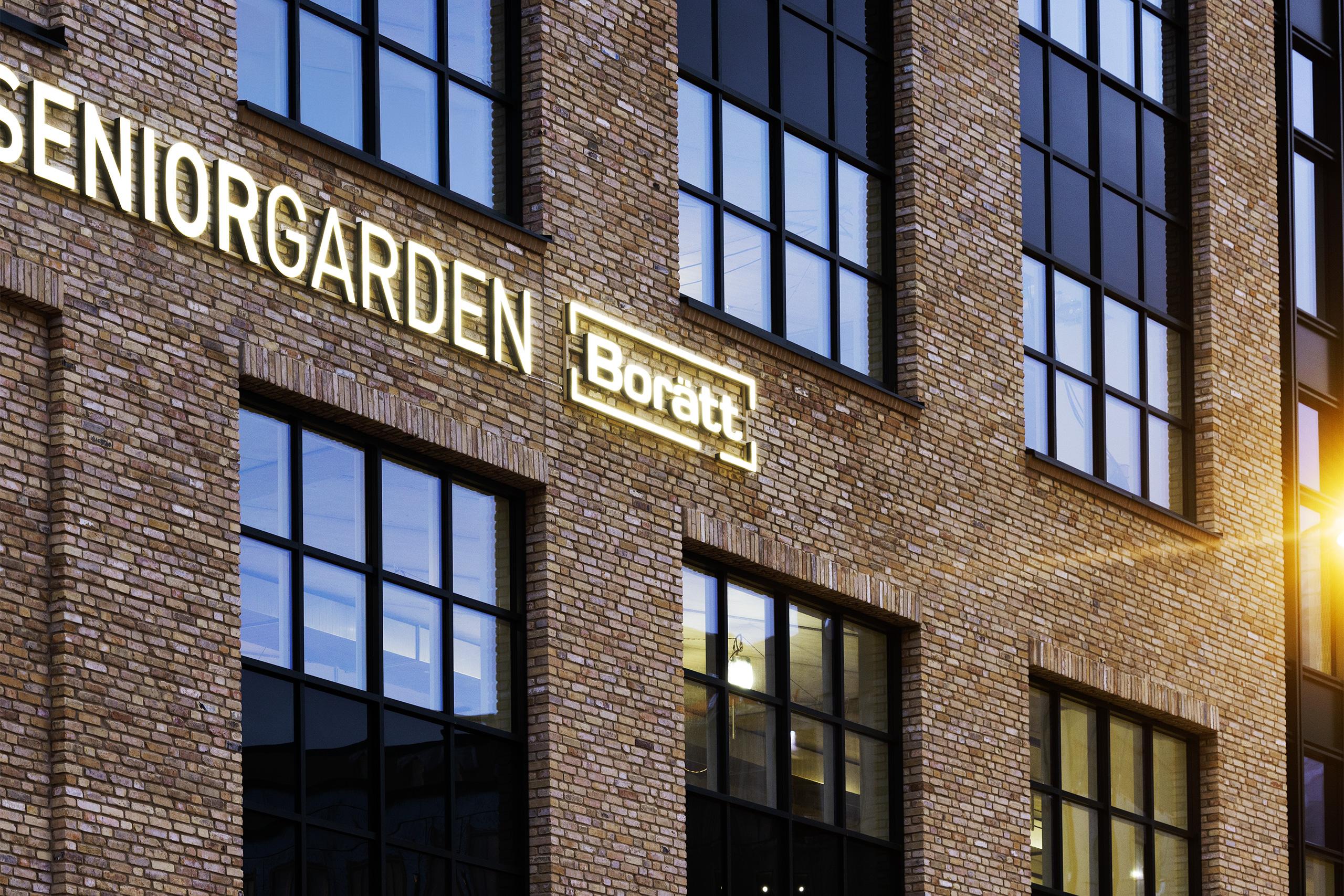 Tegelfasad med loggor Seniorgården och Borätt.