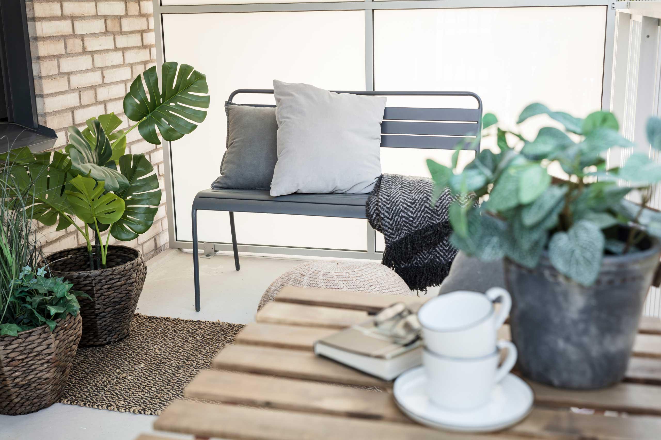 Balkong med många gröna växter.