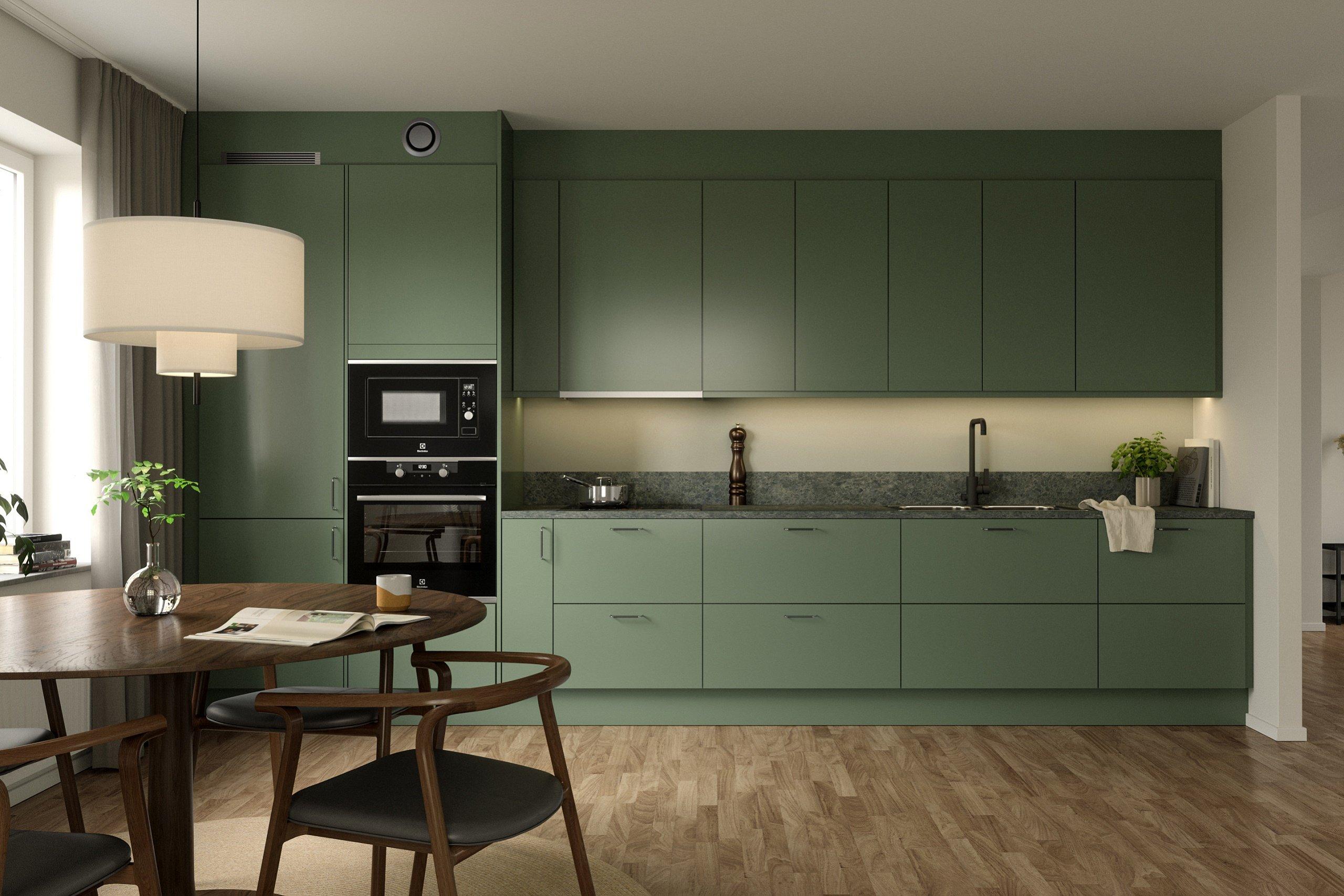 Kök med gröna skåpluckor och ekparkett.