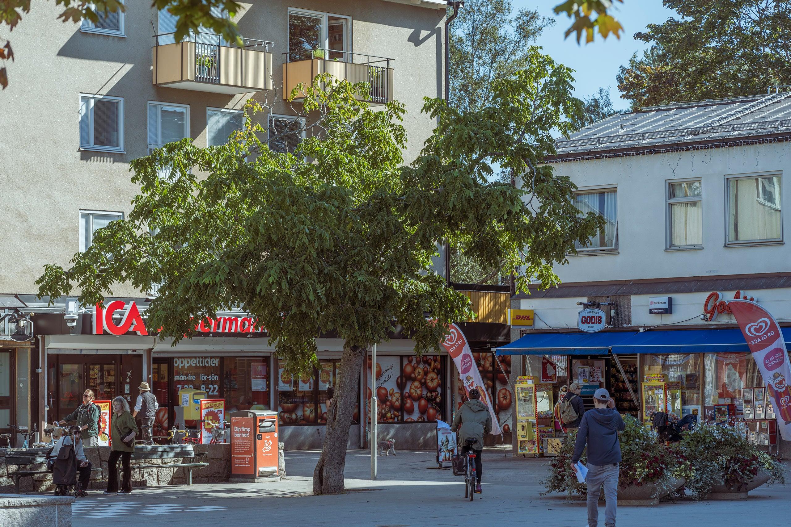 50-talstorg med butiker och sittplatser.