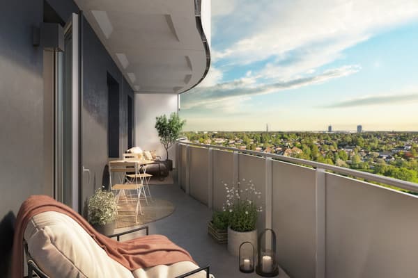 Stor, svängd balkong med utsikt över gröna trädkronor.