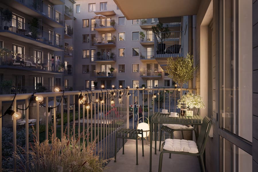 Balkong mot innergård i somrigt kvällsljus.